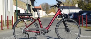 Vélo urbain éléec Sunn ON rouge dans décor fond vue principale