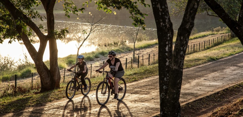 Deux cyclistes font du vélo sur un sentier en bordure d'un plan d'eau
